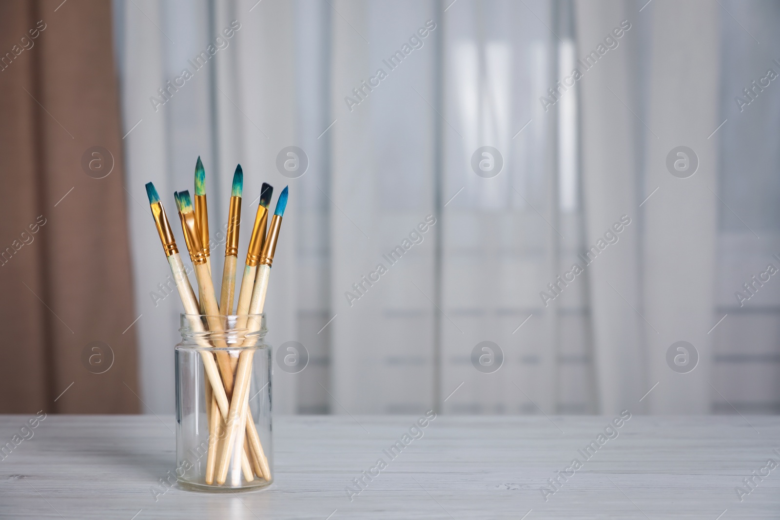 Photo of Many different paintbrushes on white wooden table indoors, space for text