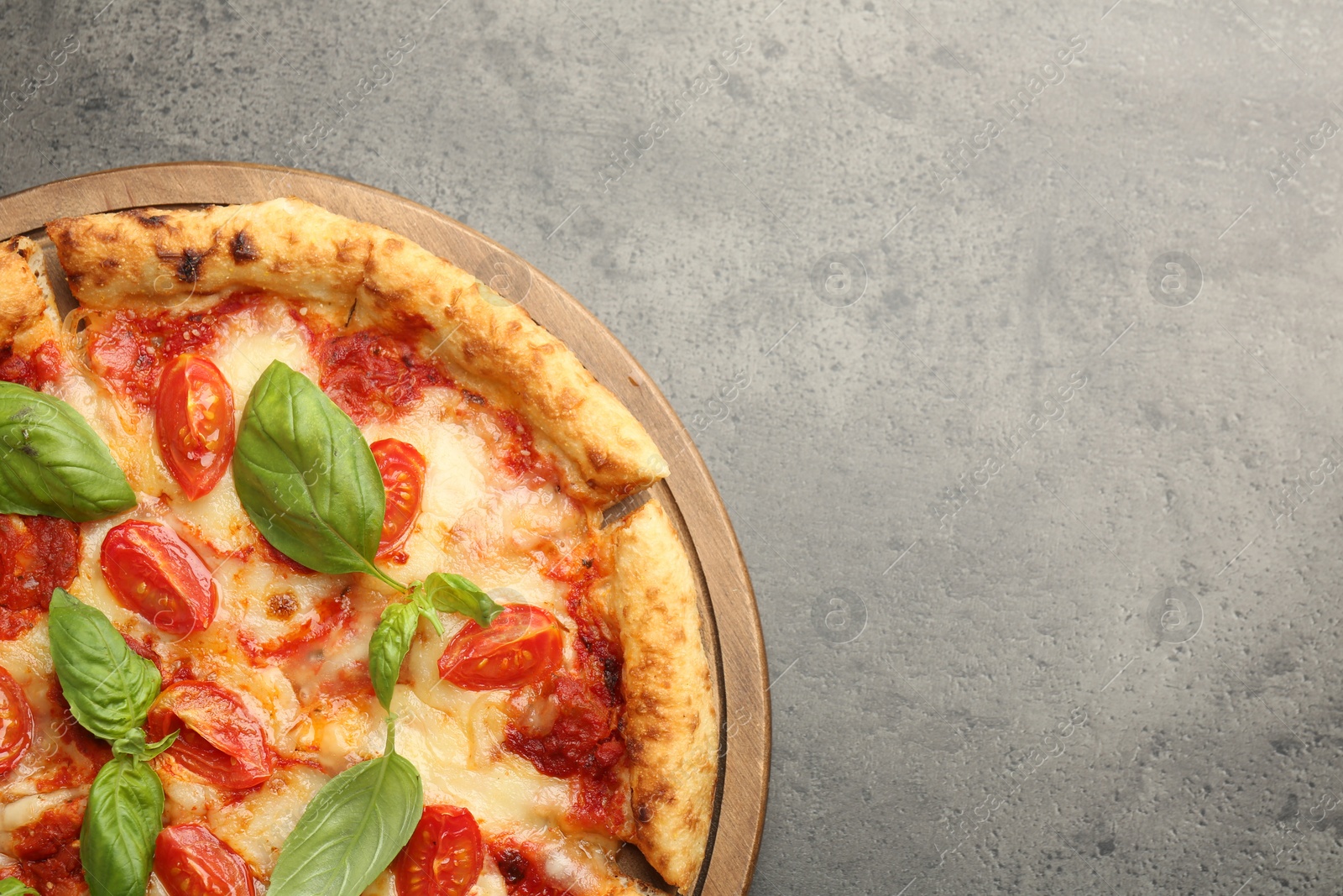 Photo of Delicious Margherita pizza on grey table, top view. Space for text