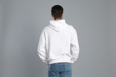 Young man in sweater on grey background. Mock up for design