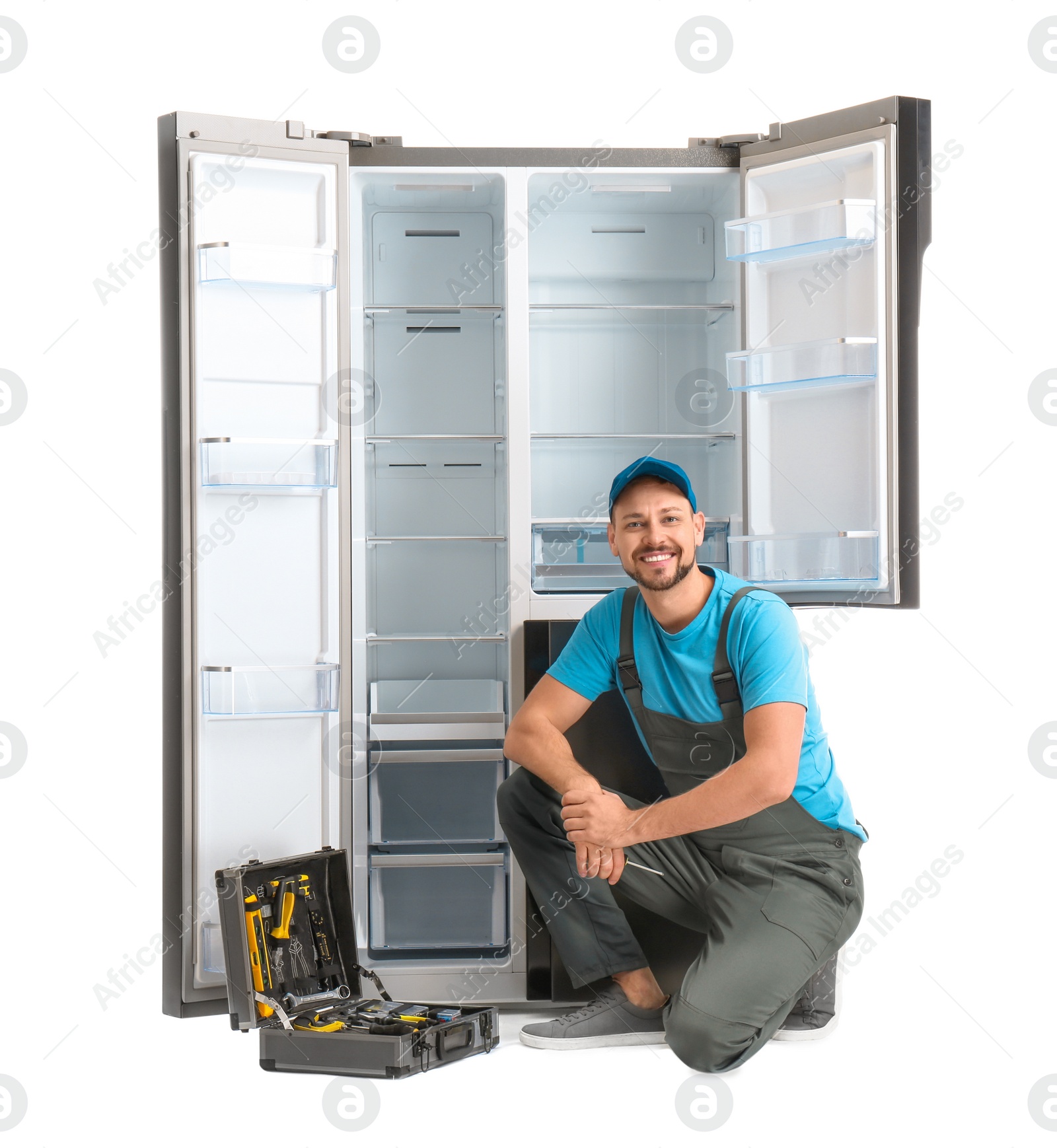 Photo of Male technician with tool box near refrigerator on white background