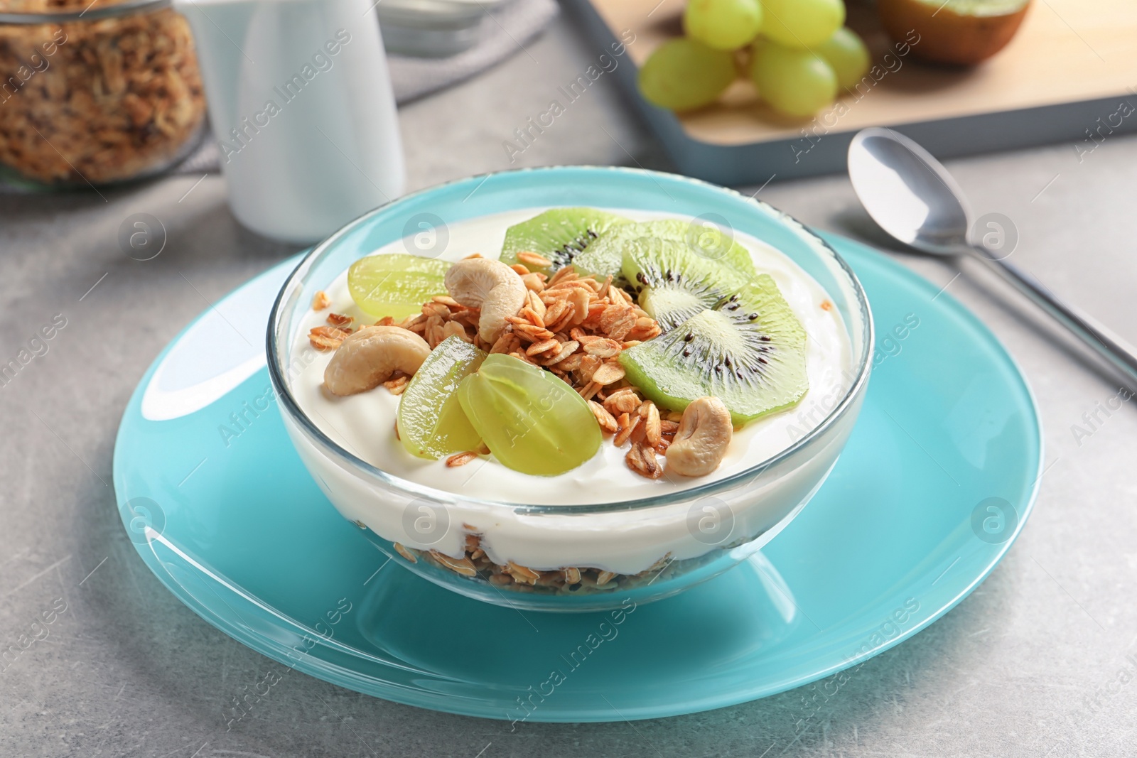Photo of Bowl with yogurt, fruits and granola on table