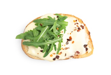 Slice of bread with spread and arugula on white background, top view