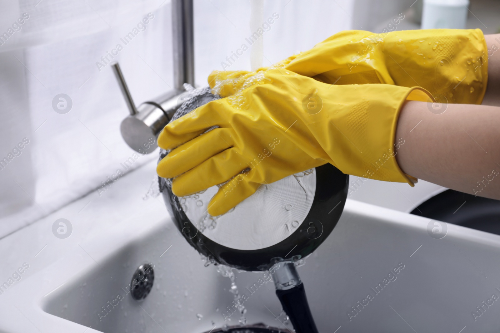 Photo of Woman washing dirty dishes in kitchen sink, closeup