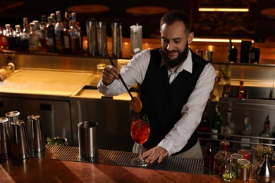 Photo of Bartender making fresh alcoholic cocktail at bar counter. Space for text