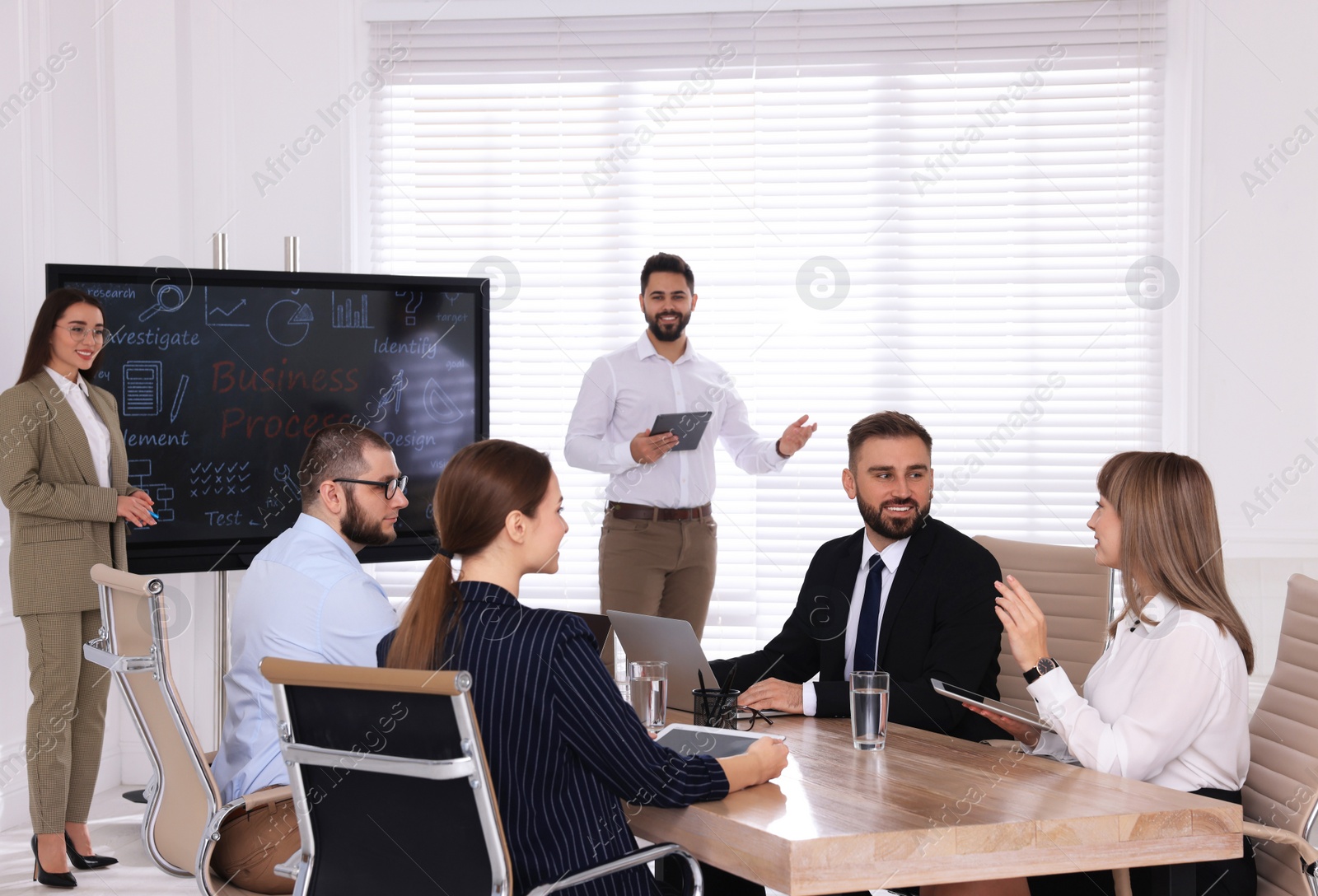 Photo of Business training. People in meeting room with interactive board