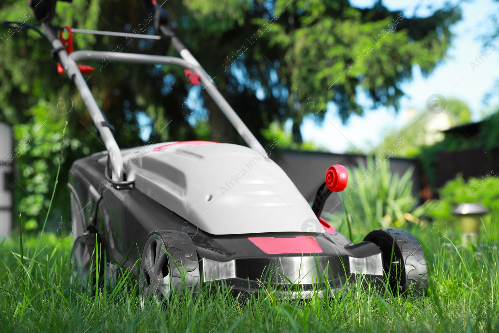 Photo of Lawn mower on green grass in garden