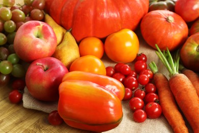 Photo of Different fresh ripe vegetables and fruits on wooden table, closeup