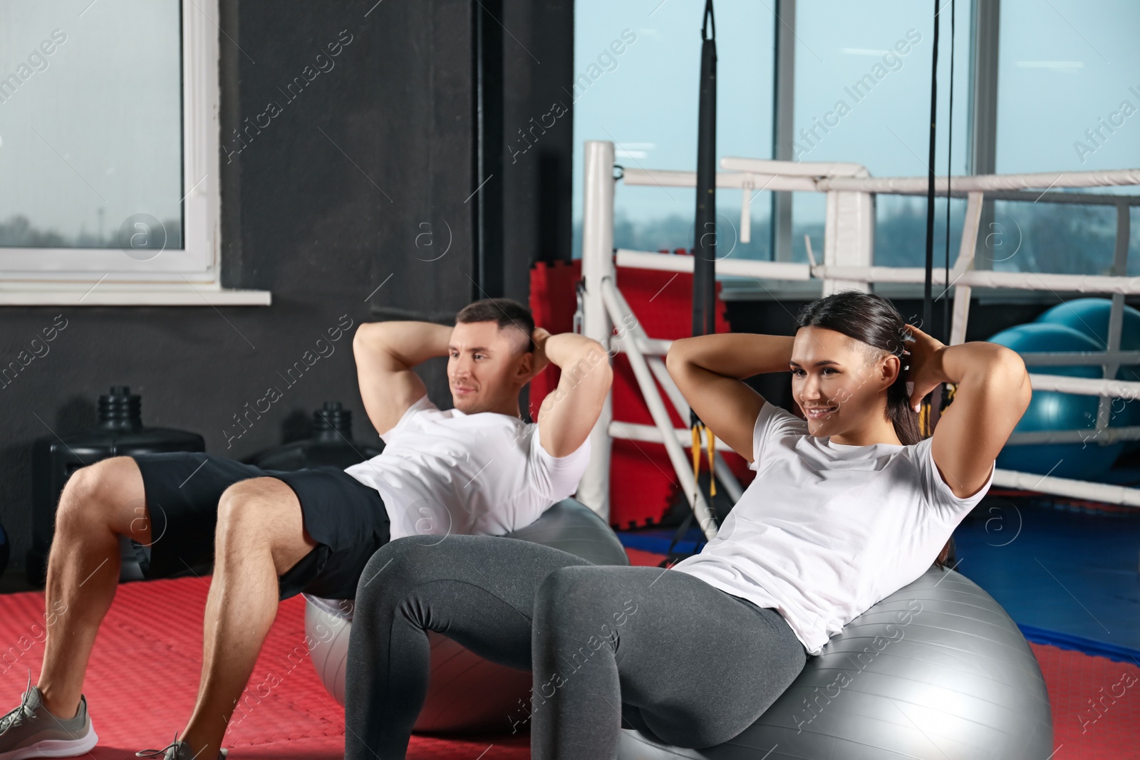 Photo of Couple working out on fit balls in gym