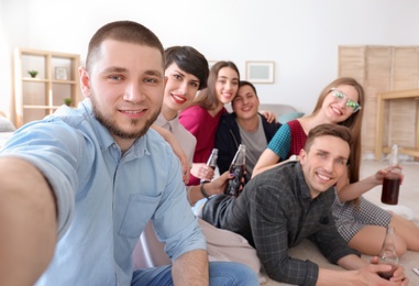 Happy friends taking selfie indoors