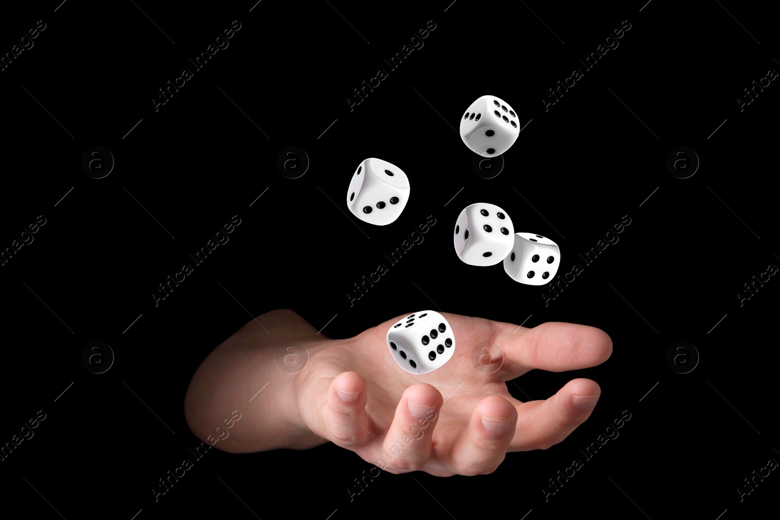 Image of Man throwing white dice on black background, closeup
