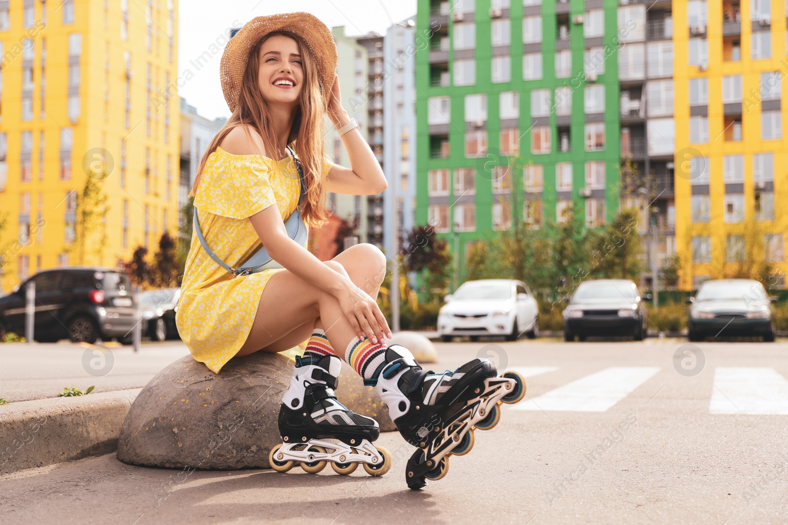 Photo of Beautiful young woman with roller skates outdoors, space for text