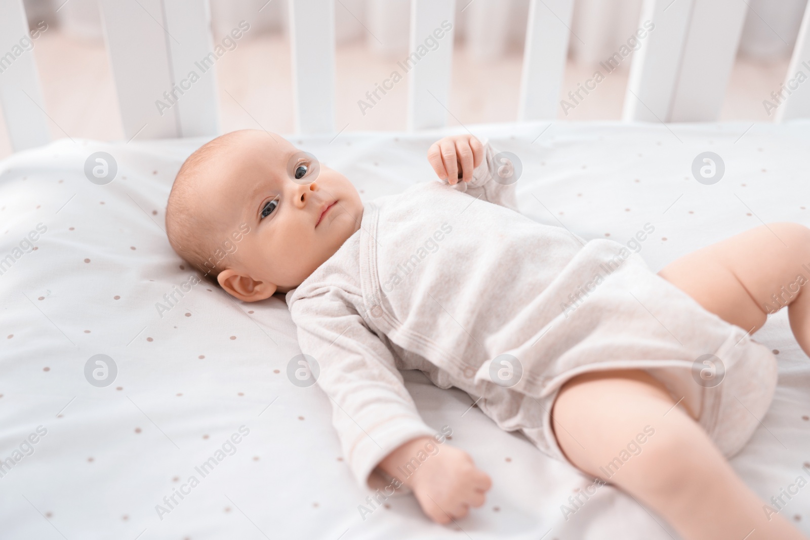 Photo of Cute little baby lying in crib at home