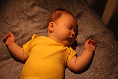 Photo of Cute newborn baby sleeping in crib at night, top view