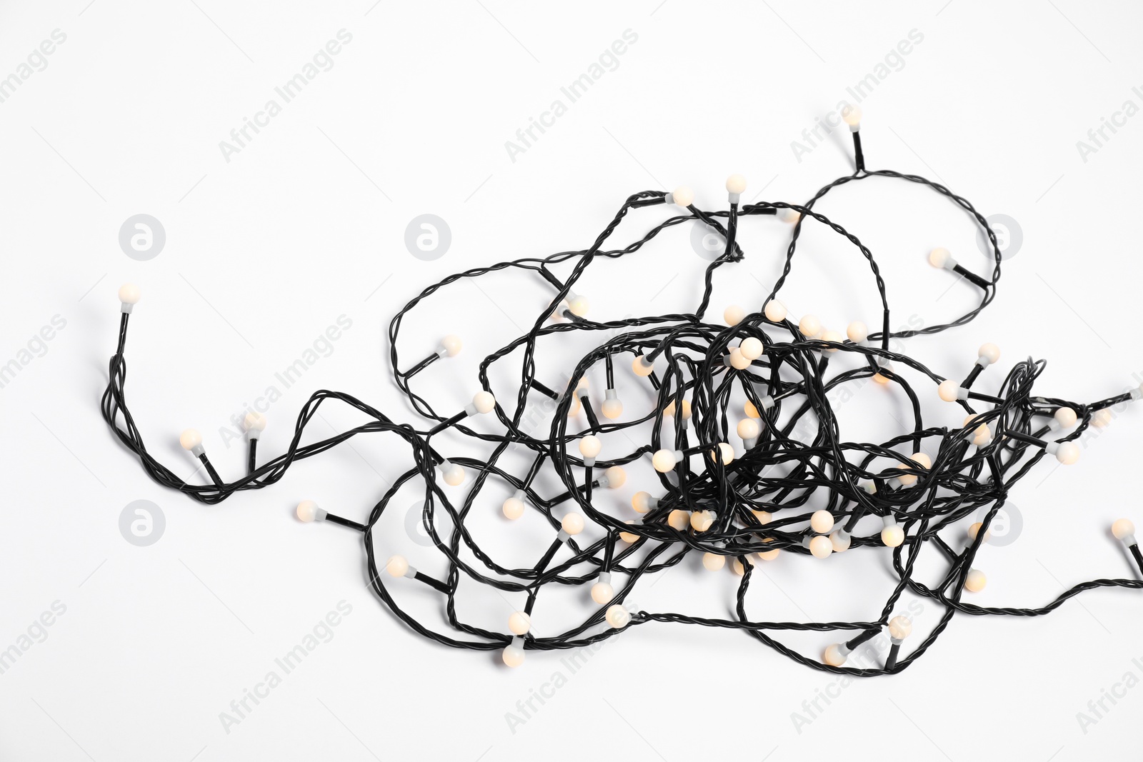 Photo of Tangled strings of Christmas lights on white background