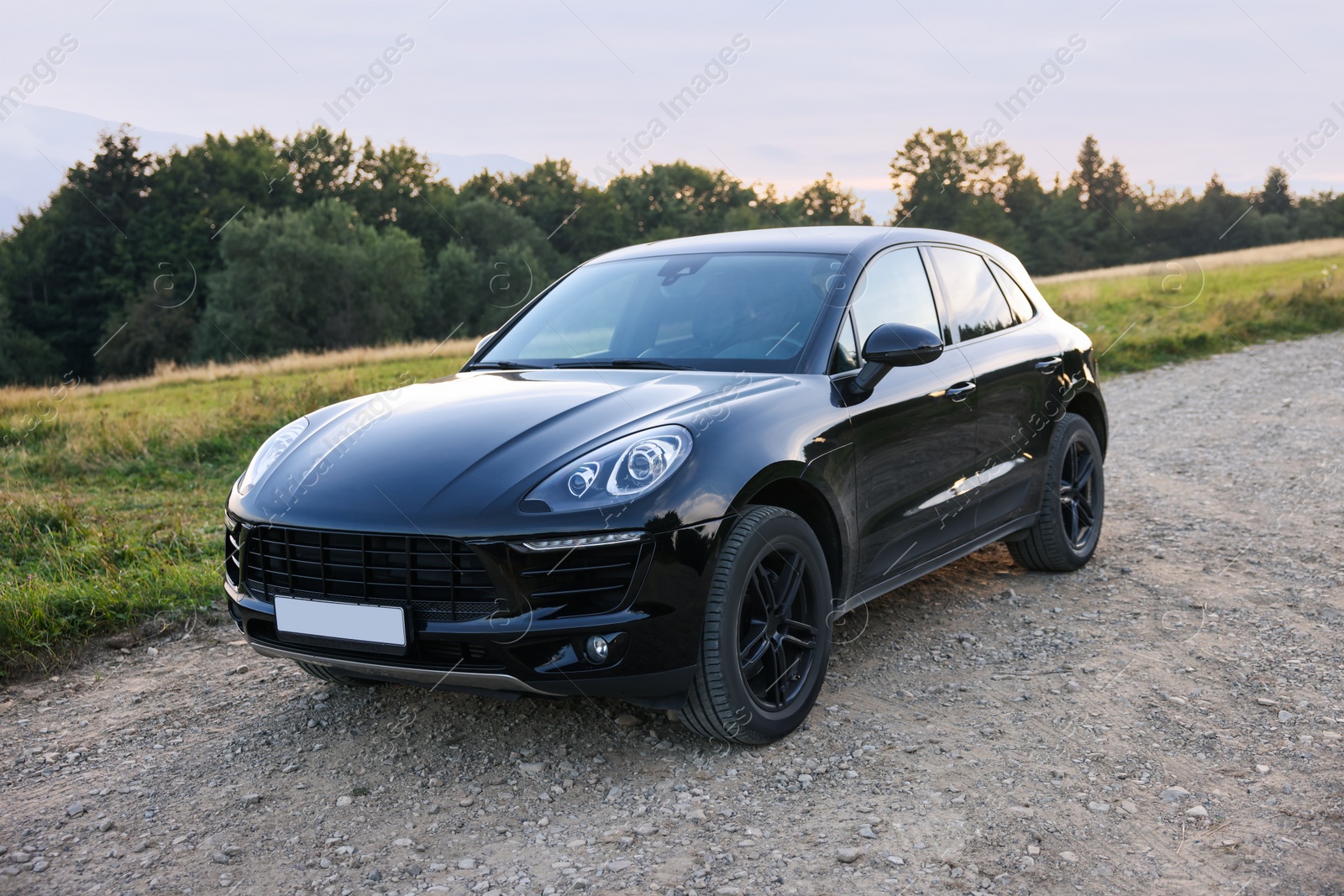 Photo of Modern black car parked on roadside outdoors