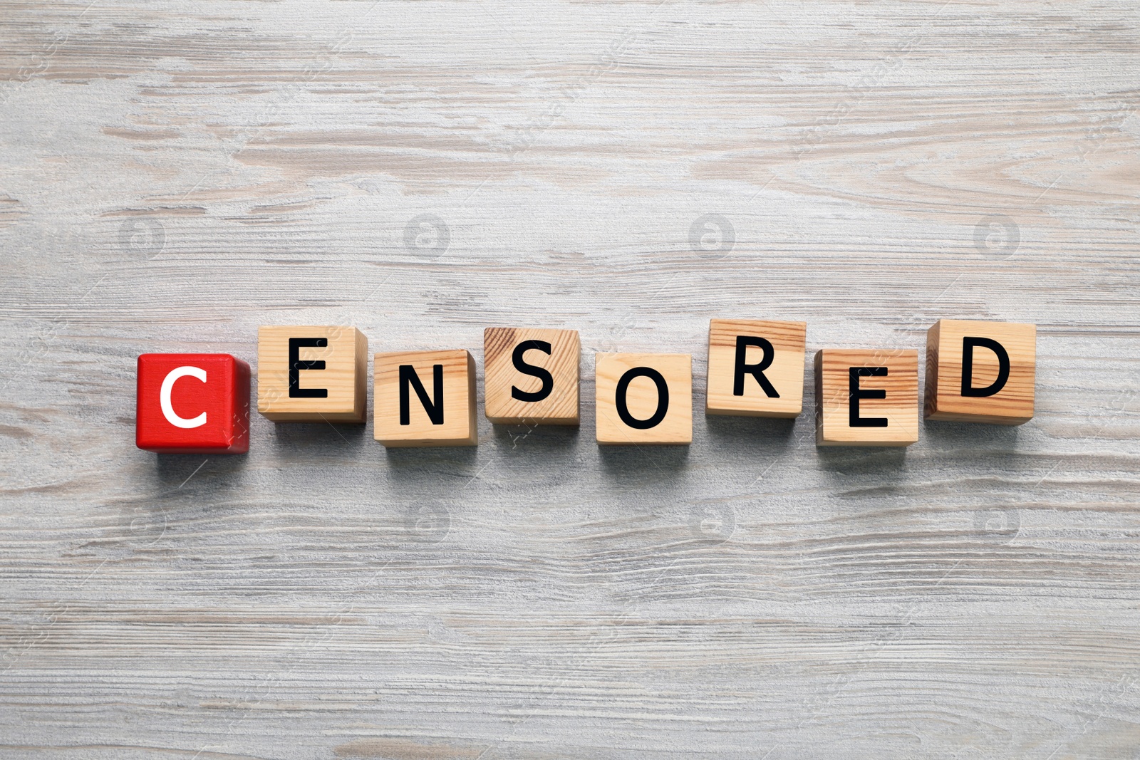 Photo of Cubes with word Censored on wooden table, flat lay