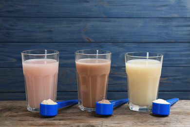 Protein shakes and powder on wooden table