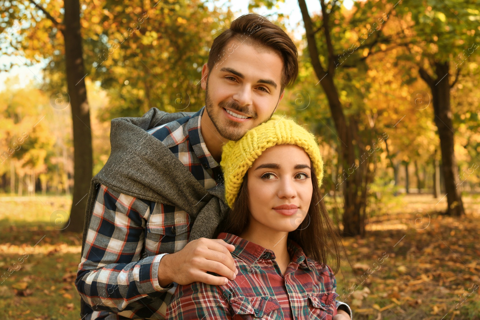 Photo of Young lovely couple spending time together in park. Autumn walk
