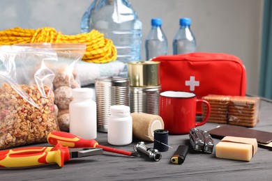Photo of Disaster supply kit for earthquake on black wooden table indoors
