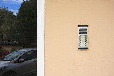 Photo of Modern intercom on beige wall, space for text. Security system
