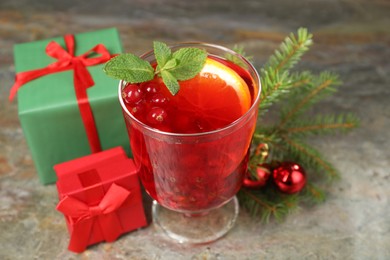 Photo of Aromatic Christmas Sangria in glass, gift boxes and festive decor on textured table