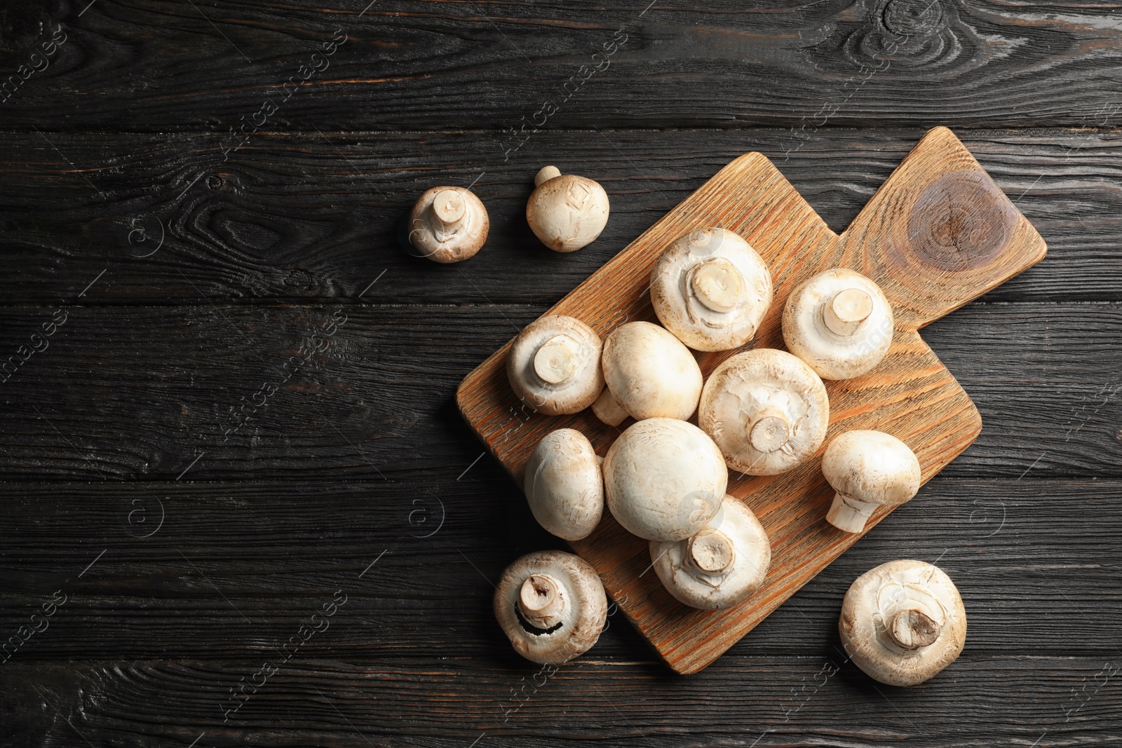 Photo of Flat lay composition with fresh champignon mushrooms on wooden table. Space for text