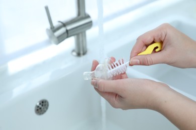 Photo of Woman washing baby bottle nipple, closeup and space for text