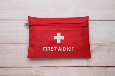 Photo of Medicine bag on wooden table, top view. First aid kit