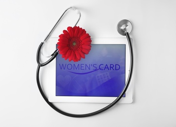 Tablet and stethoscope on white background, top view. Gynecology concept