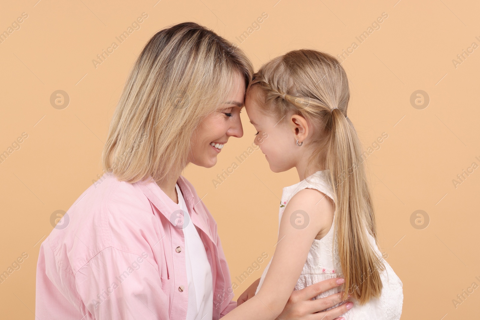 Photo of Family portrait of happy mother and daughter on beige background