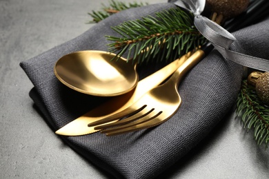 Photo of Cutlery set and Christmas decor on grey table, closeup