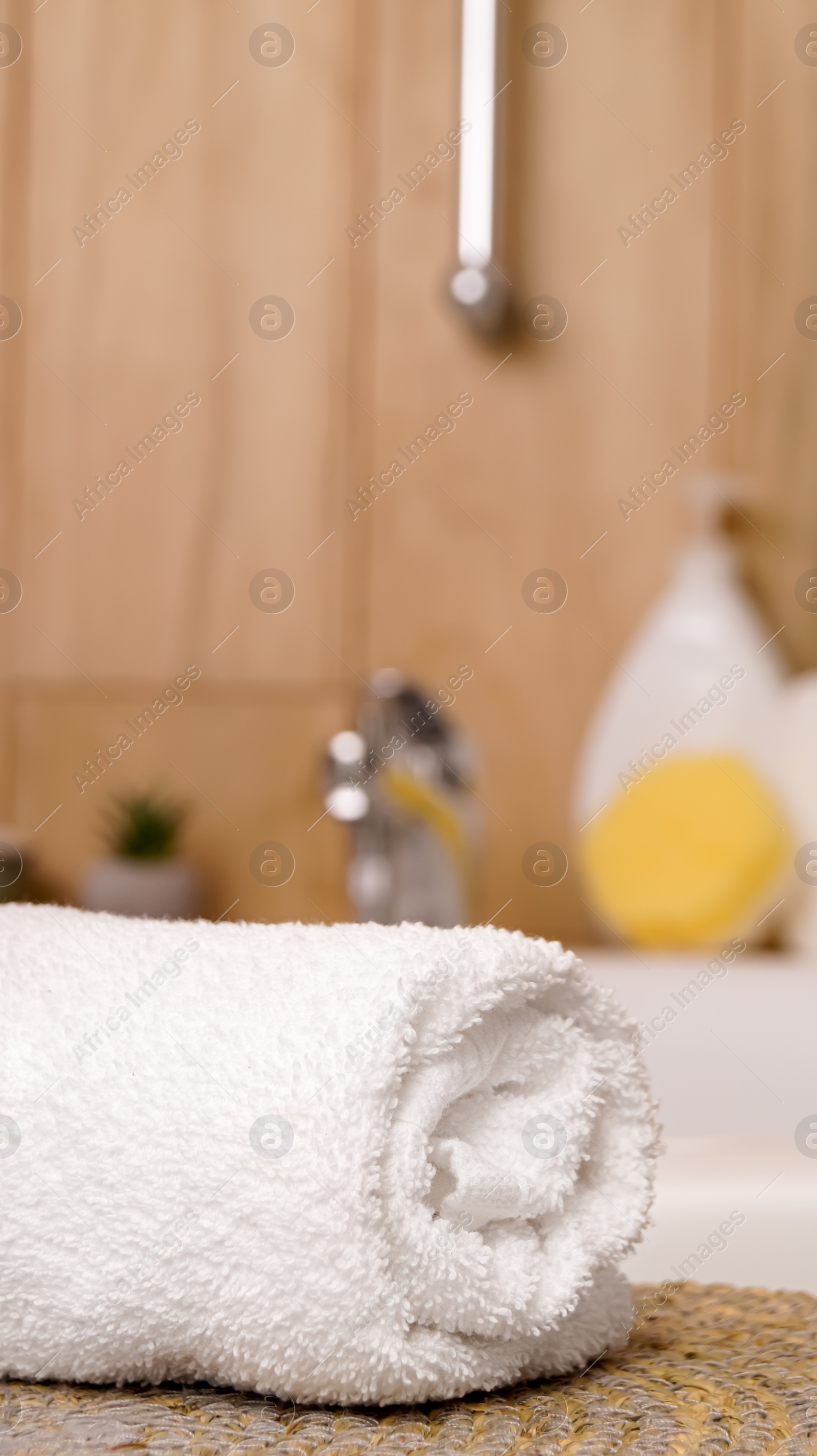 Photo of Rolled bath towel on table in bathroom
