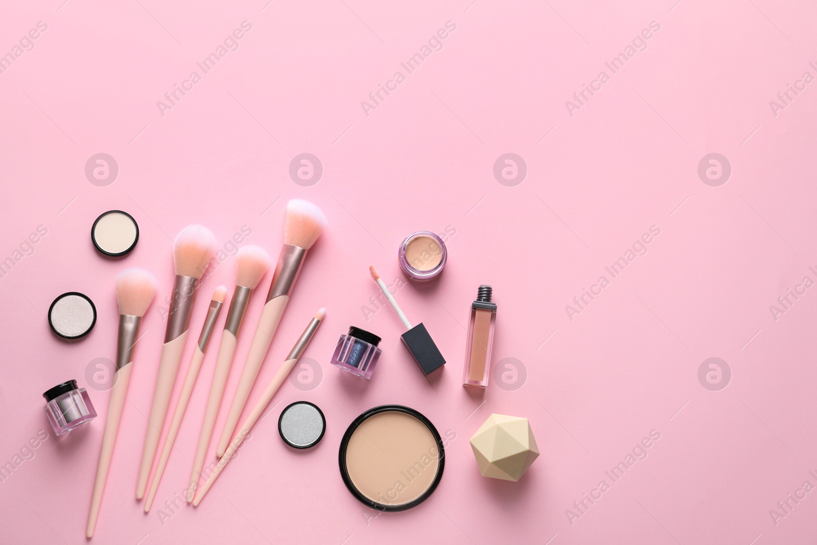 Photo of Flat lay composition with makeup brushes on pink background. Space for text