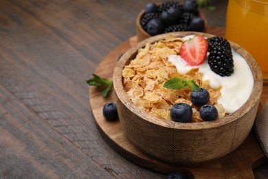 Delicious crispy cornflakes, yogurt and fresh berries in bowl on wooden table, closeup with space for text. Healthy breakfast