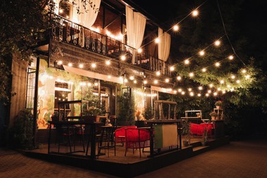Photo of Beautiful view of modern cafe with outdoor terrace at night