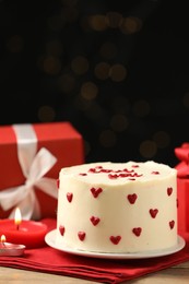 Photo of Bento cake, candles and gift box on wooden table. St. Valentine's day surprise