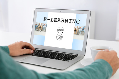 Man using laptop for online studying indoors, closeup. Adult education 