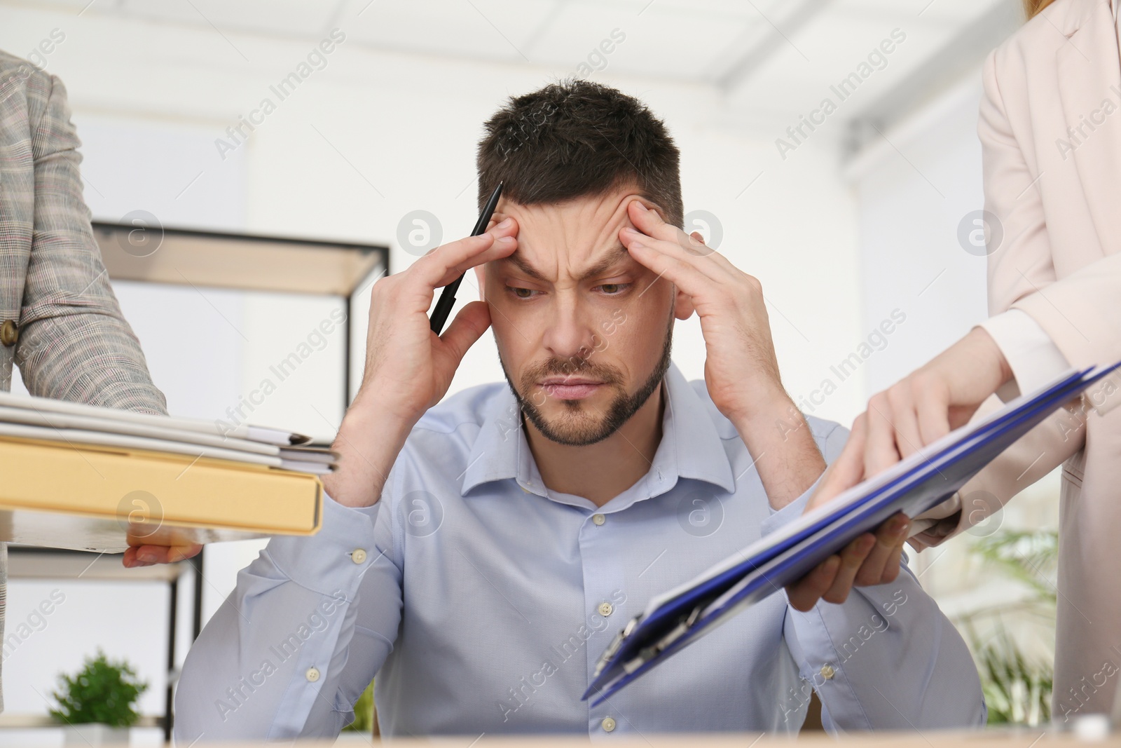 Photo of Businessman stressing out at workplace in office