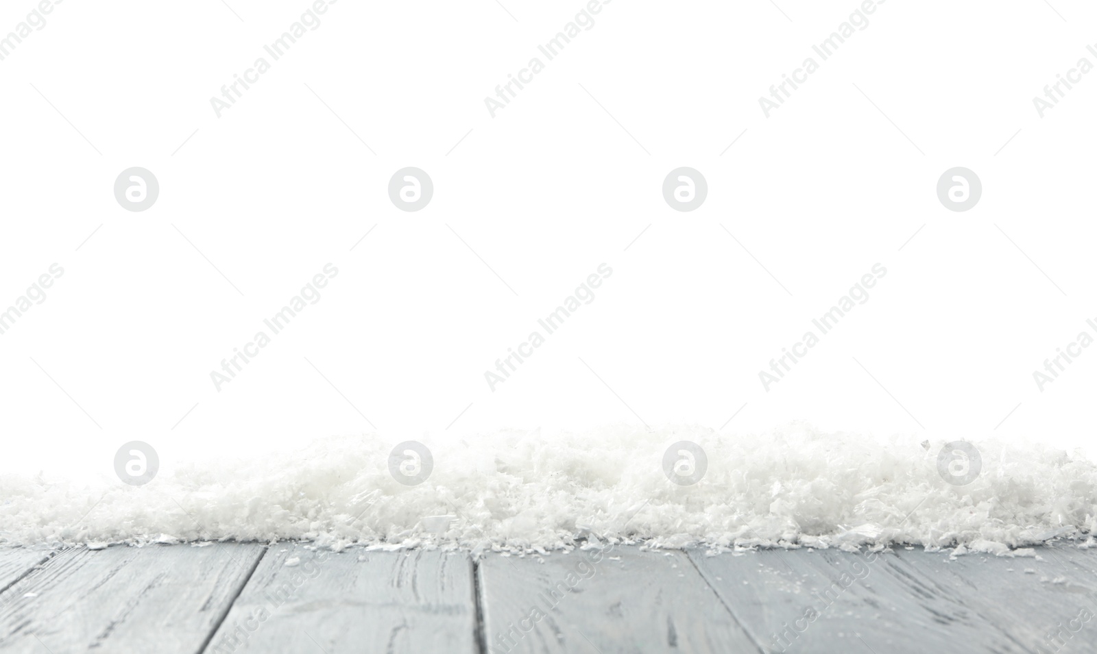 Photo of Snow on grey wooden surface against white background. Christmas season