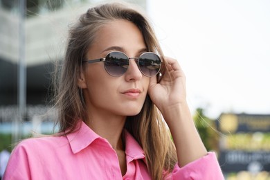 Photo of Beautiful young woman in stylish sunglasses outdoors