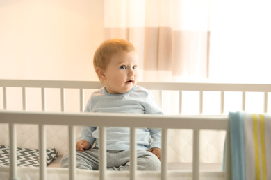 Photo of Cute little baby in crib at home