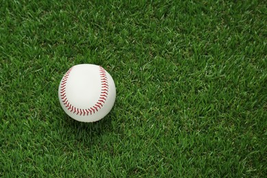 Photo of Baseball ball on green grass, top view with space for text. Sports game
