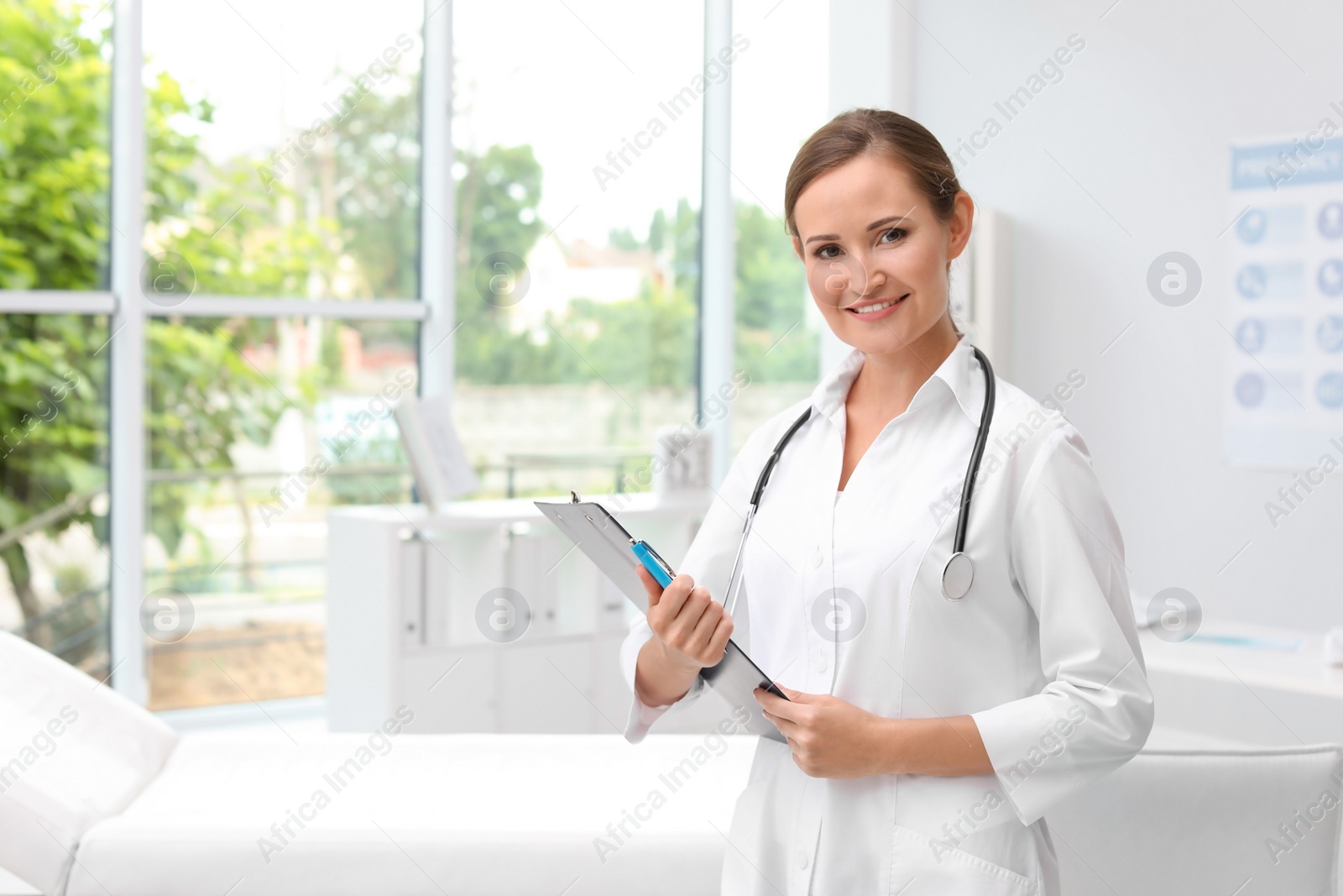 Photo of Female doctor with clipboard in hospital. Patient attendance