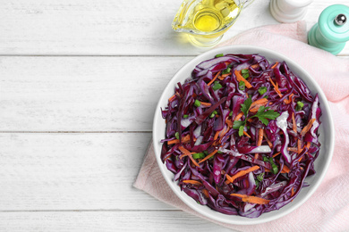 Photo of Fresh red cabbage salad served on white wooden table, flat lay. Space for text
