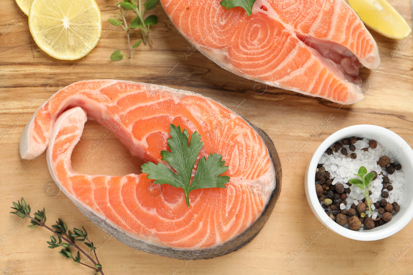 Photo of Fresh salmon and ingredients for marinade on wooden board, flat lay