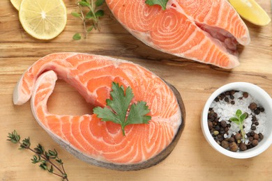 Photo of Fresh salmon and ingredients for marinade on wooden board, flat lay