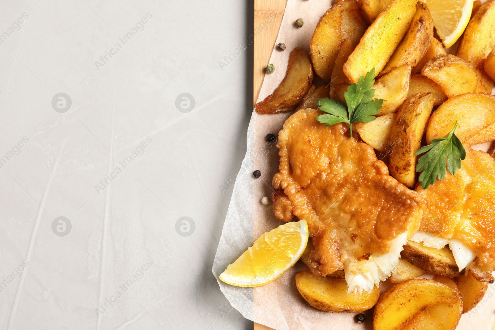 Photo of British traditional fish and potato chips on table, top view with space for text