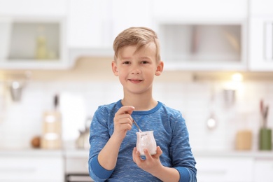 Photo of Little boy with yogurt on blurred background