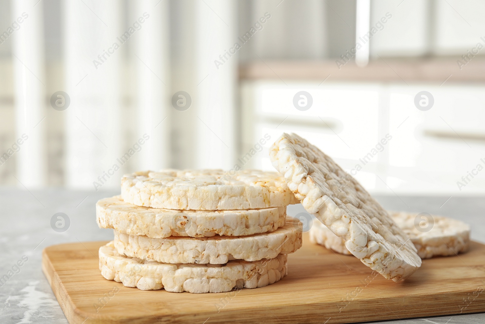 Photo of Stack of crunchy rice cakes on grey marble table indoors