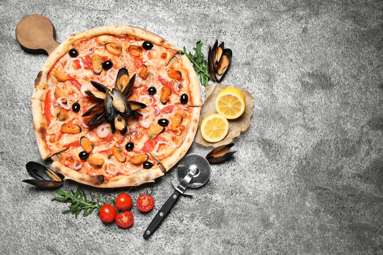 Photo of Tasty pizza with seafood and ingredients on grey table, flat lay. Space for text